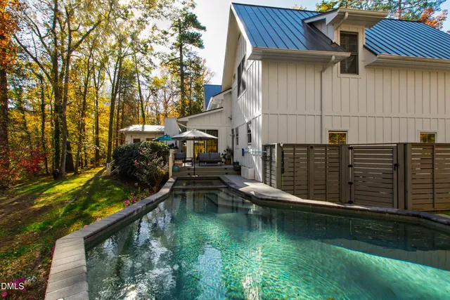 a view of house with swimming pool and outdoor seating