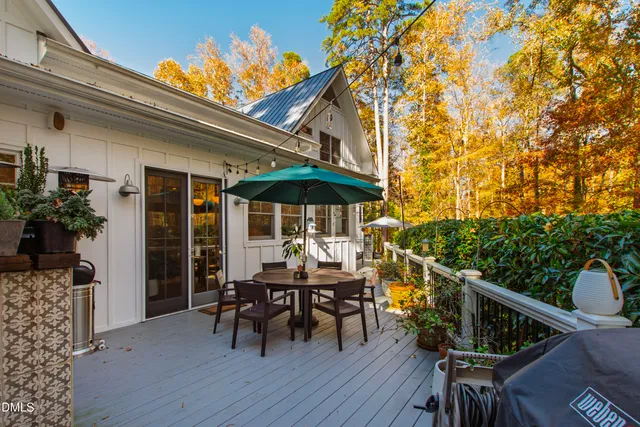 a view of patio with table and chairs under an umbrella with wooden floor
