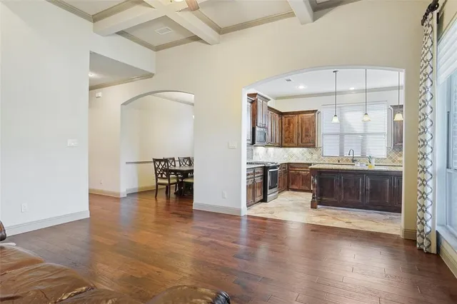 a kitchen with stainless steel appliances granite countertop a stove a sink a oven a dining table and chairs