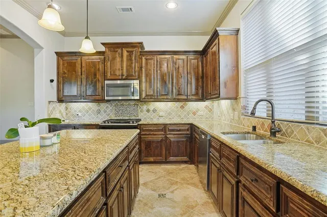 a kitchen with kitchen island granite countertop a sink appliances and cabinets