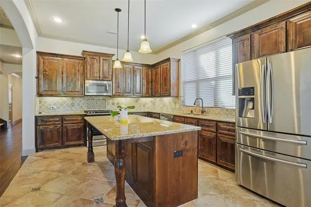 a kitchen with granite countertop cabinets stainless steel appliances and a counter space