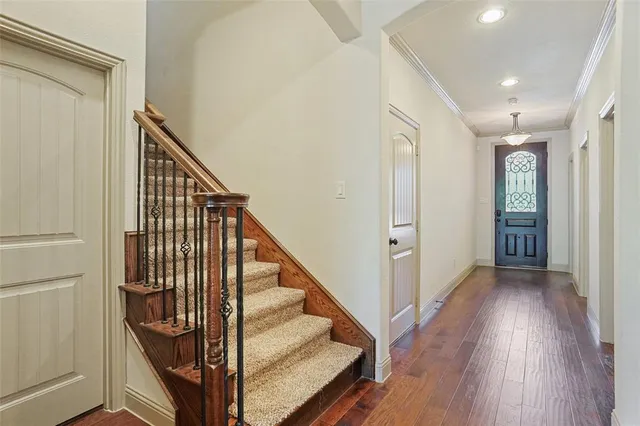 a view of a hallway with wooden floor and staircase