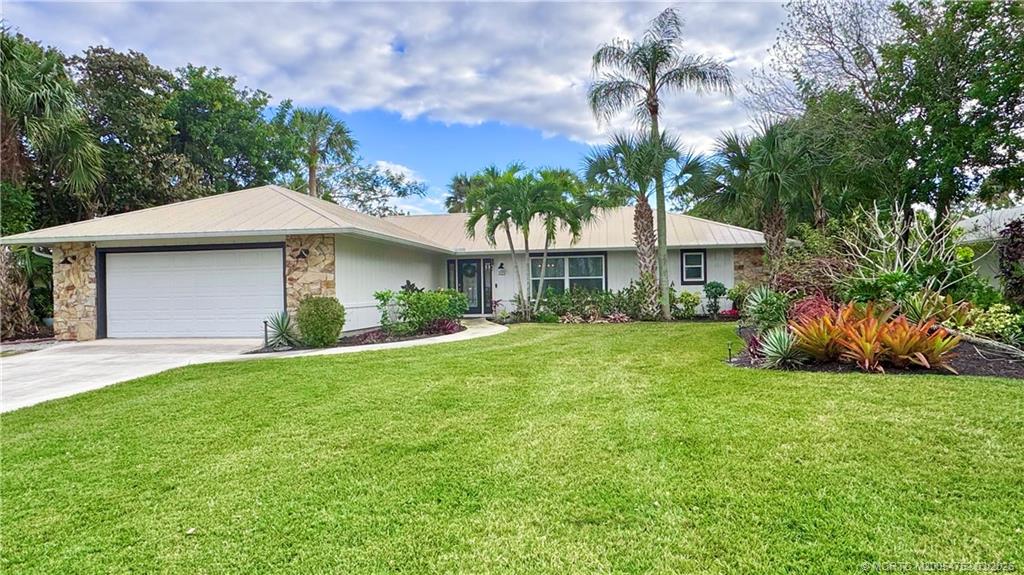 323 Southwest Ridge Lane Stuart, FL 34994 - Photo 2 of 18 a front view of a house with garden