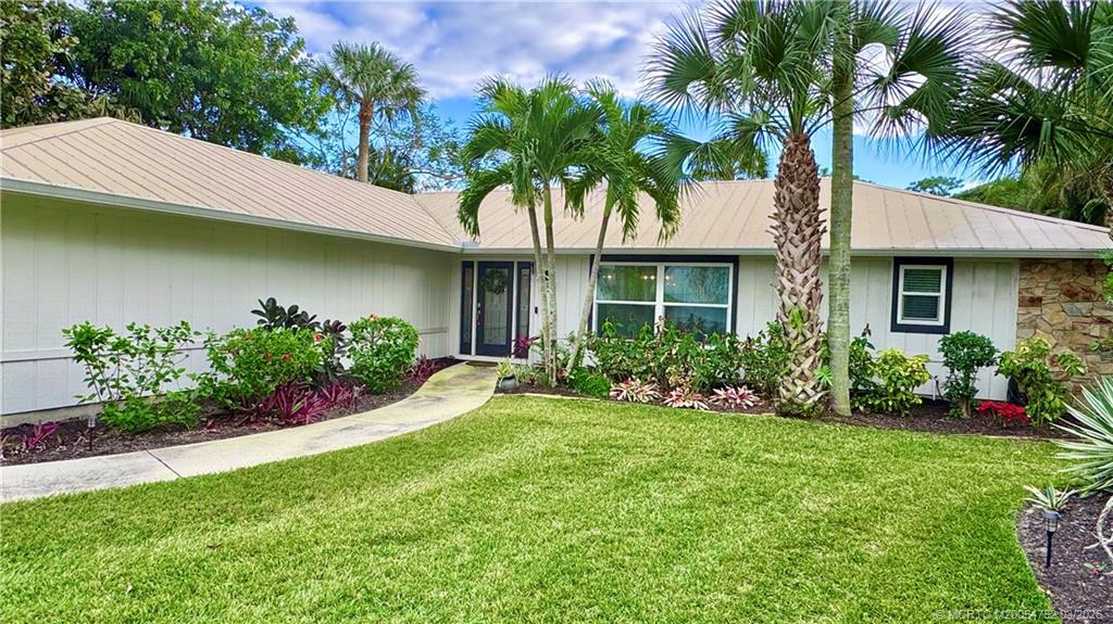 323 Southwest Ridge Lane Stuart, FL 34994 - Photo 4 of 18 a front view of a house with a garden