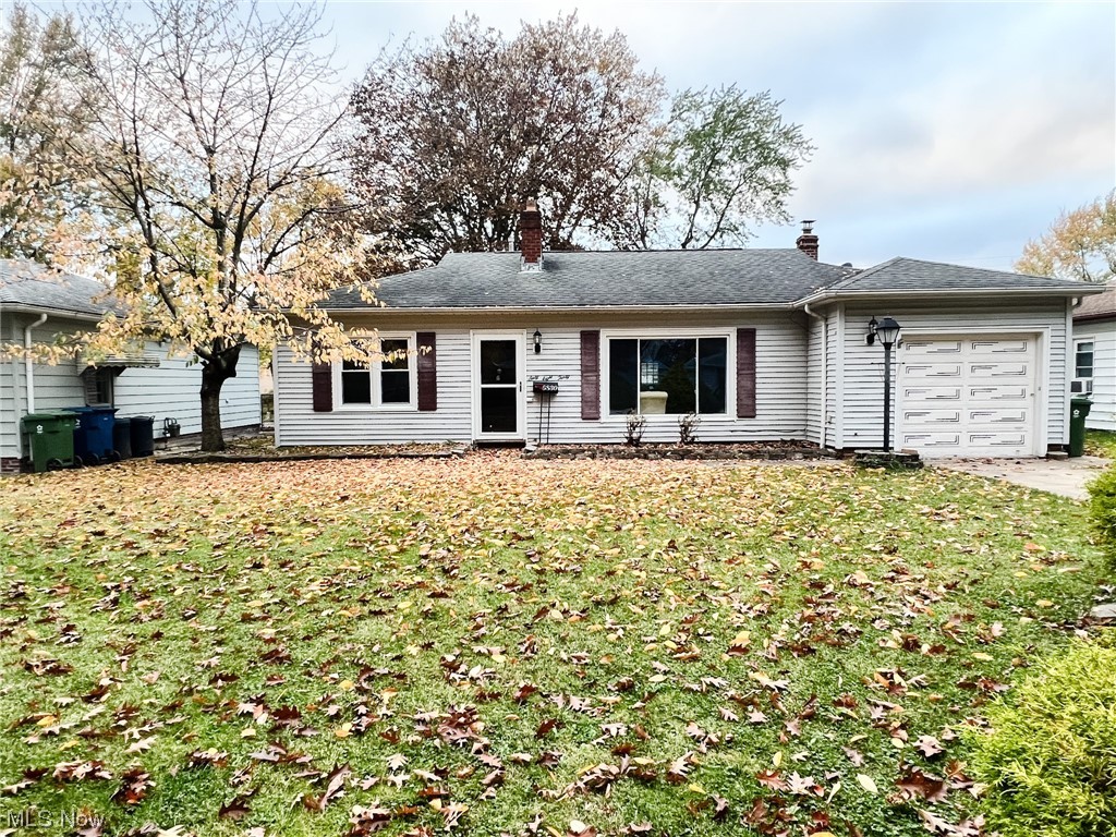 Single story home with a garage and a front yard