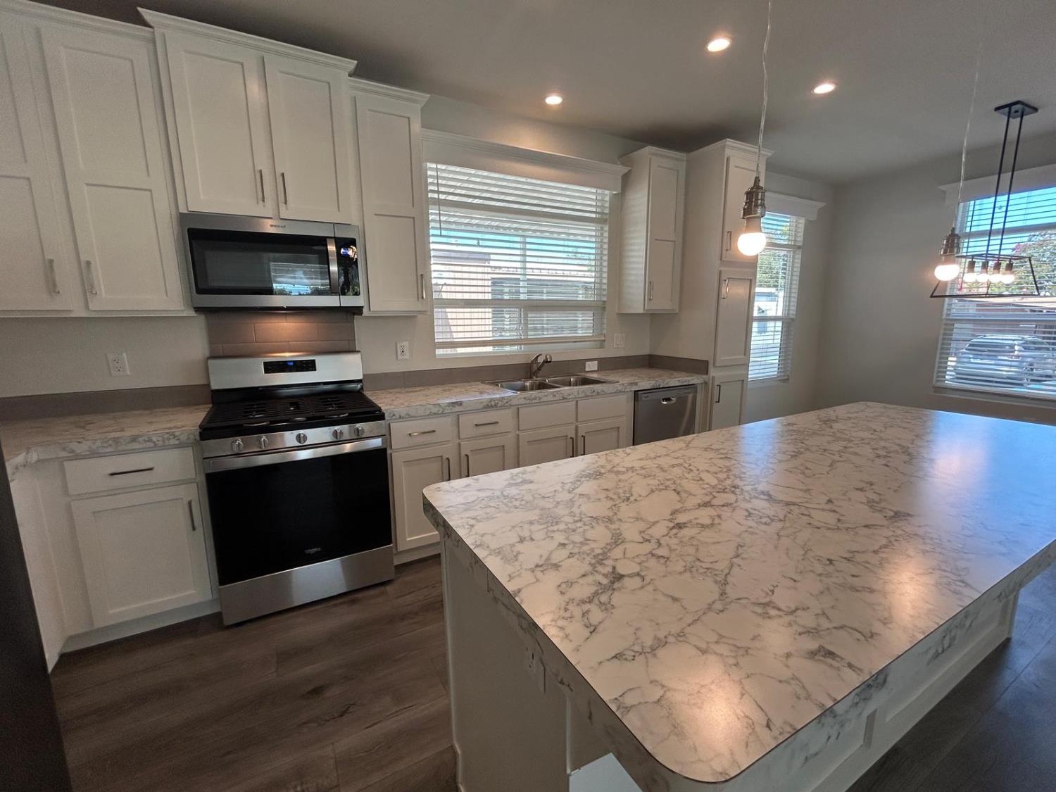 9060 Auburn Folsom Road, Unit 25 Granite Bay, CA 95746 - Photo 12 of 29 a kitchen with stainless steel appliances kitchen island granite countertop a stove a sink and a microwave