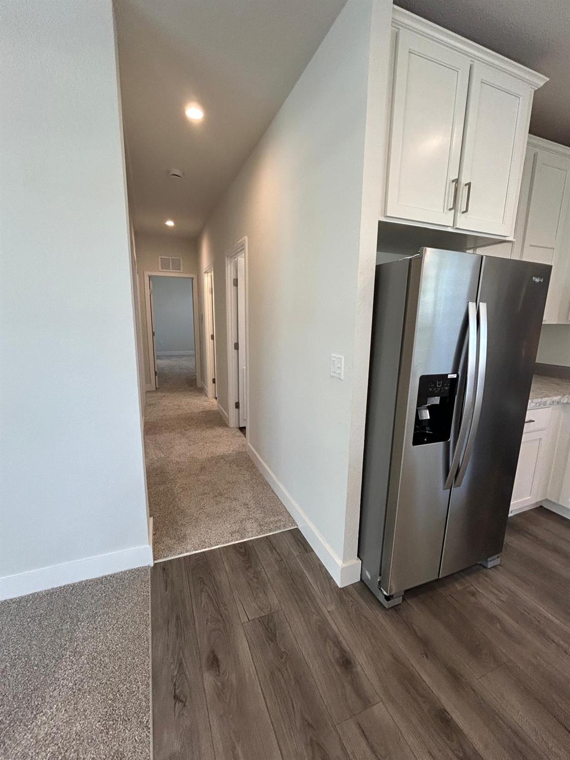 9060 Auburn Folsom Road, Unit 25 Granite Bay, CA 95746 - Photo 13 of 29 a view of a refrigerator in kitchen and wooden floor