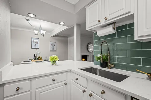 a view of a sink and dishwasher with cabinets