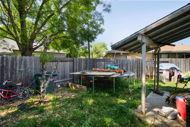 a view of a backyard with chairs potted plants and wooden fence