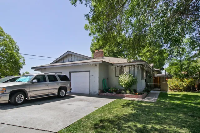 a view of a backyard with table and chairs and a large tree