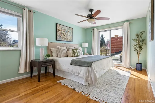 a bedroom with a bed a dresser and painting on the wall