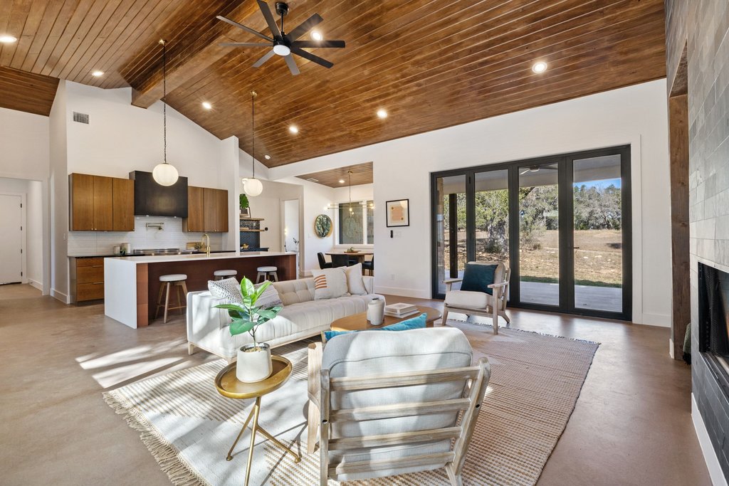 47 War Bonnet Wimberley, TX 78676 - Photo 18 of 40 Living area featuring high vaulted ceiling, concrete floors, a large fireplace, a wooden ceiling with exposed beams, and ceiling fan