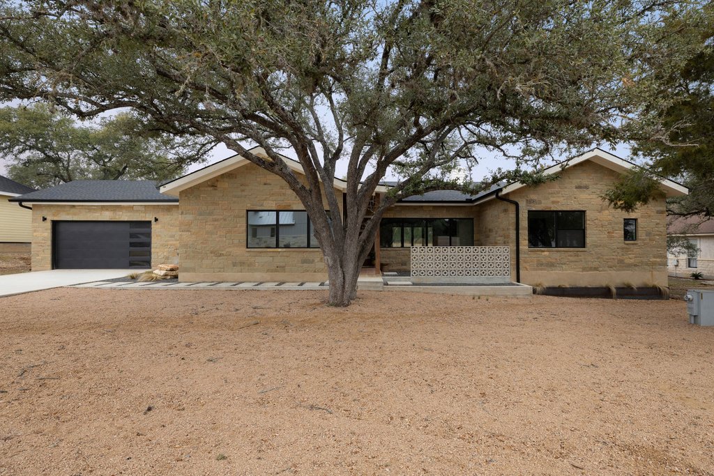 47 War Bonnet Wimberley, TX 78676 - Photo 2 of 40 View of front of property with a garage, concrete driveway, and brick siding