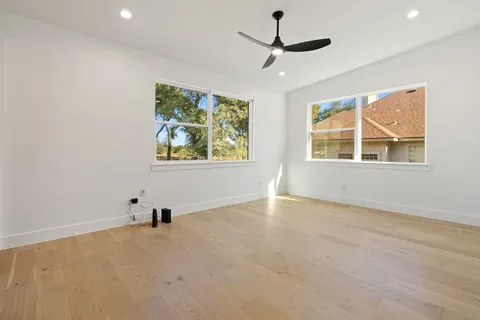 an empty room with windows and fan