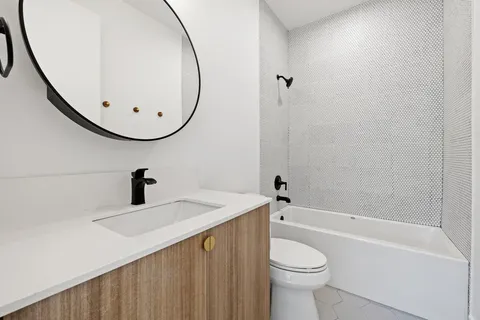 a bathroom with a sink a toilet and a mirror