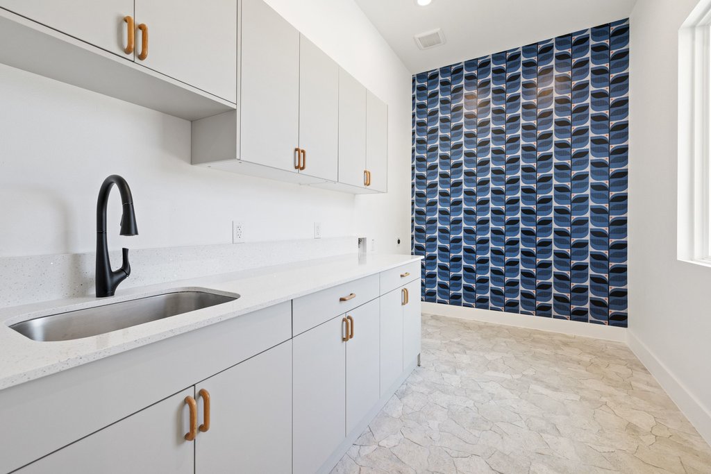 47 War Bonnet Wimberley, TX 78676 - Photo 35 of 40 Kitchen with an accent wall, light stone countertops, white cabinetry, and recessed lighting