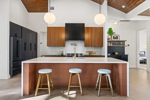 a kitchen with stainless steel appliances granite countertop a stove top oven a sink a counter top space and cabinets