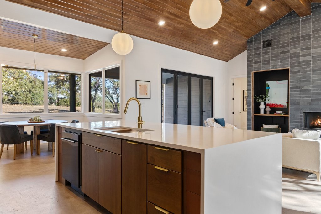 47 War Bonnet Wimberley, TX 78676 - Photo 40 of 40 Kitchen with modern cabinets, hanging light fixtures, a fireplace, wood ceiling, and open floor plan