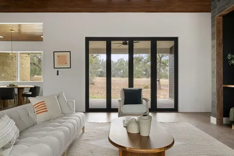 a kitchen with stainless steel appliances granite countertop a sink a stove and a dining table with wooden floor