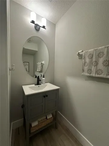 a bathroom with a sink a light fixture and a mirror