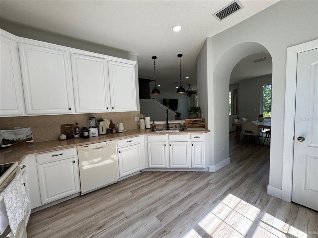 7544 Red Mill Circle New Port Richey, FL 34653 - Photo 16 of 31 a kitchen with granite countertop white cabinets and white appliances