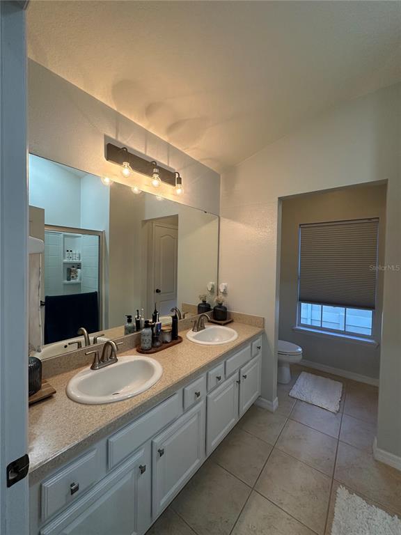 7544 Red Mill Circle New Port Richey, FL 34653 - Photo 26 of 31 a bathroom with a granite countertop sink a mirror and a