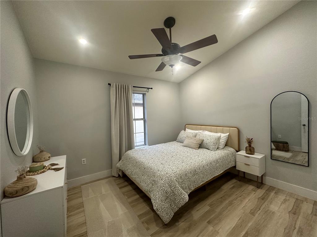 7544 Red Mill Circle New Port Richey, FL 34653 - Photo 27 of 31 a bedroom with a bed and a chandelier