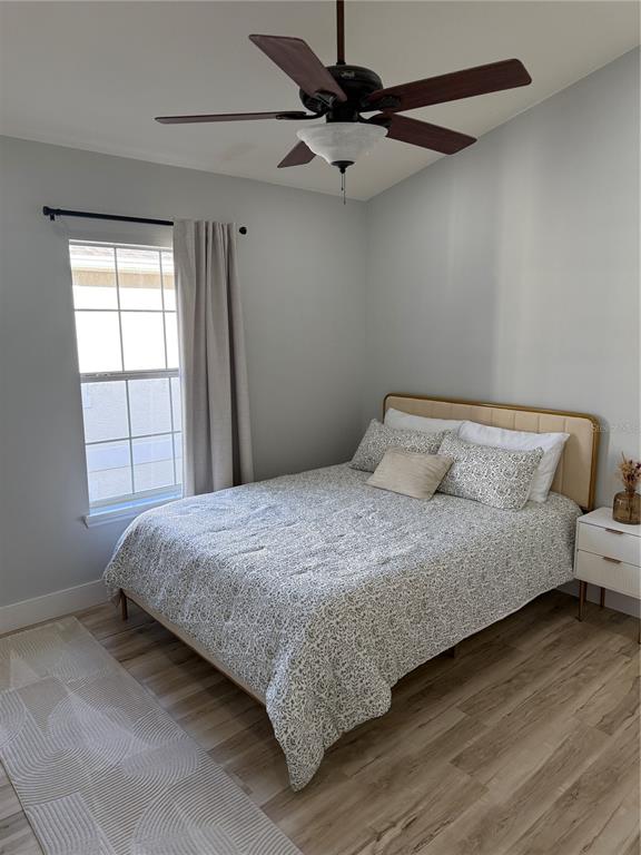 7544 Red Mill Circle New Port Richey, FL 34653 - Photo 28 of 31 a bedroom with a bed and wooden floor