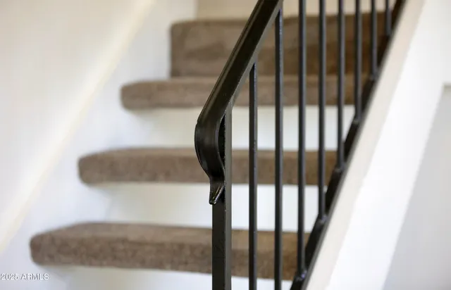 a view of staircase with wooden floor and a chandelier