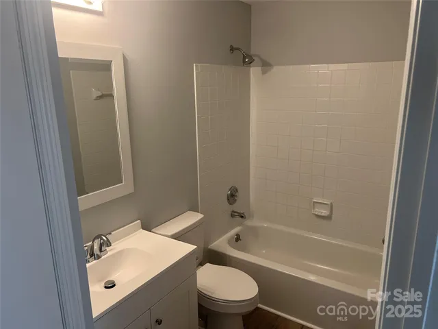 a bathroom with a bathtub shower sink vanity and toilet
