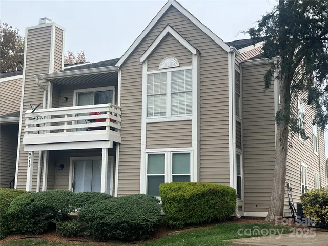 a view of a house with a yard and potted plants
