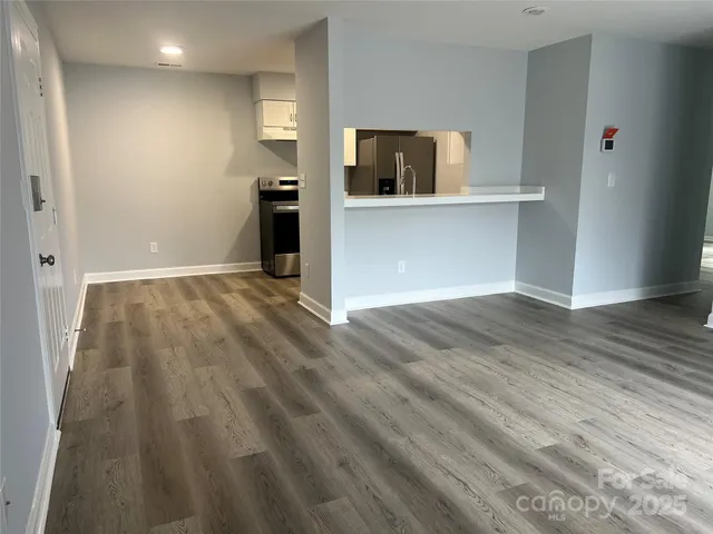 a view of a kitchen with wooden floor and electronic appliances