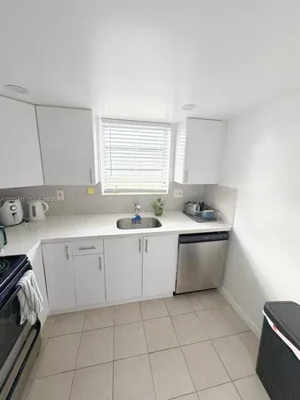 a kitchen with a sink cabinets and window