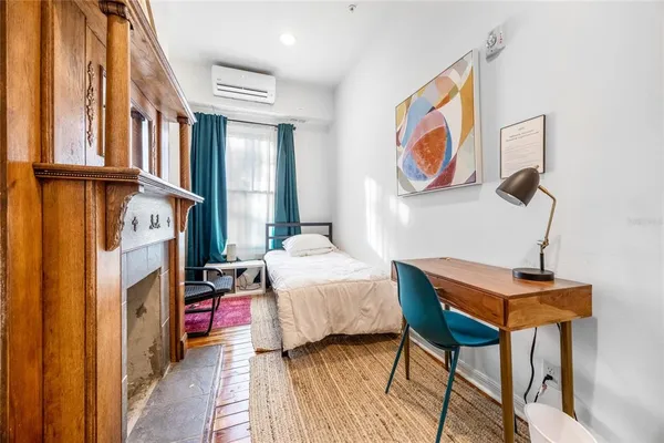 a bedroom with a bed and painting on the wall