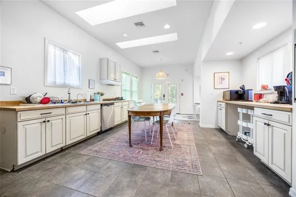 a kitchen with a dining table chairs and white cabinets