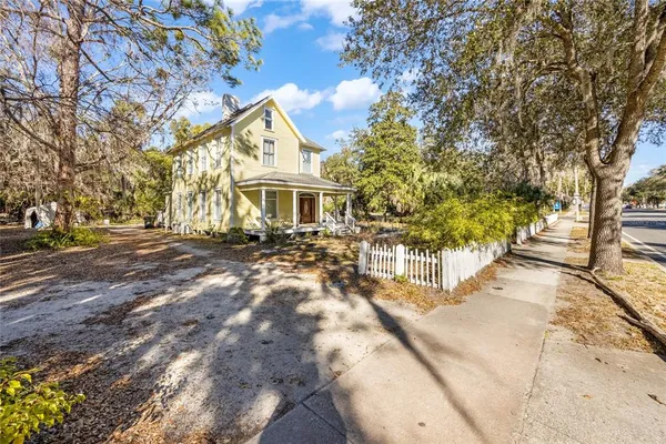 a view of house with yard and trees in the background
