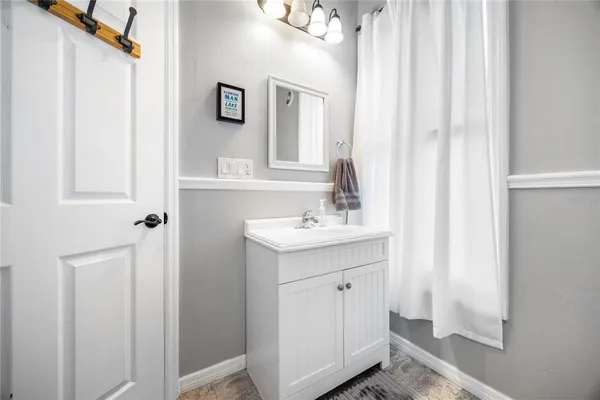 a living room with stainless steel appliances furniture and a kitchen view