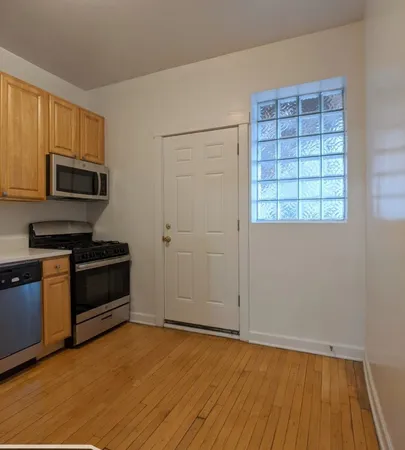 a view of a kitchen with wooden floor and electronic appliances