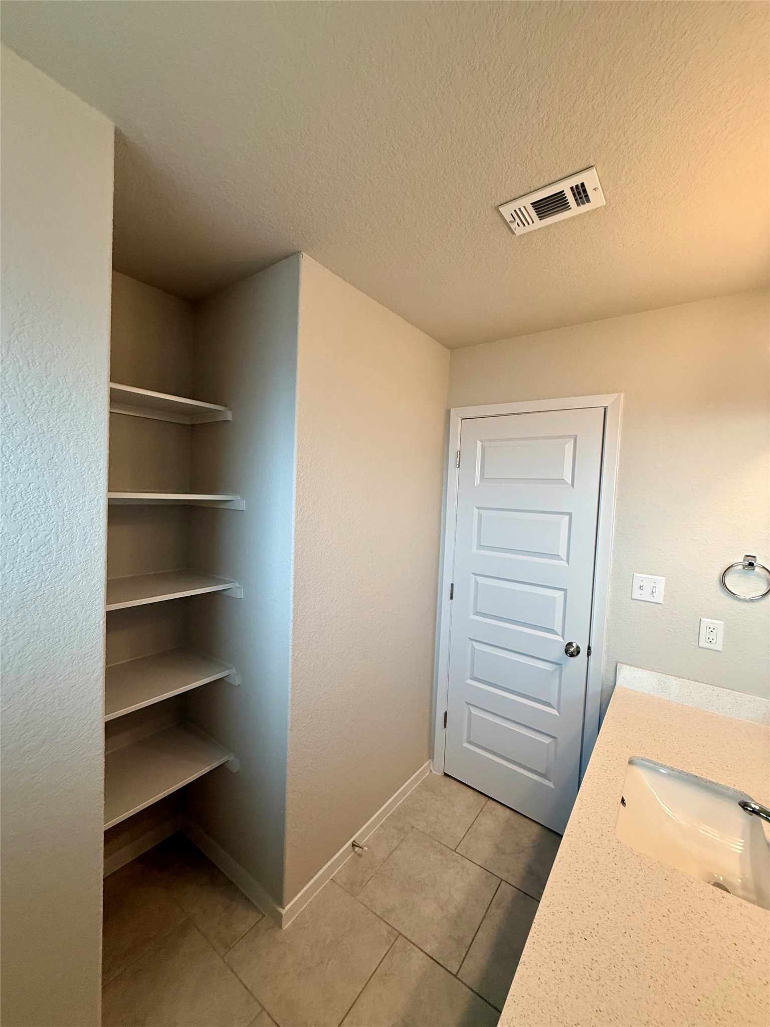 212 Lake Placid Run Elgin, TX 78621 - Photo 18 of 27 Ample shelving in this well-appointed bathroom offers convenient storage solutions.