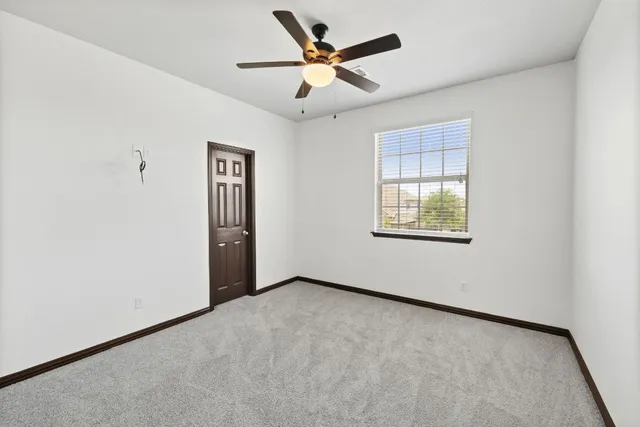 an empty room with fan and windows