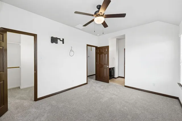 an empty room with closet and a ceiling fan