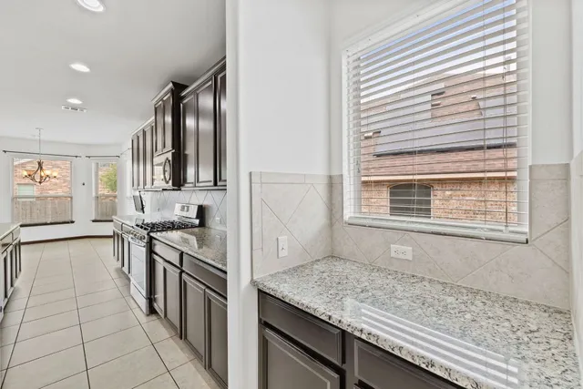 a kitchen with stainless steel appliances granite countertop a stove and a sink