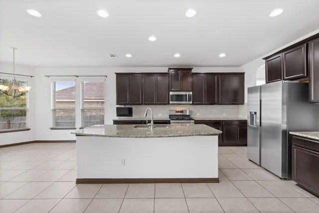 a large kitchen with stainless steel appliances and a refrigerator