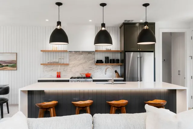 a kitchen with stainless steel appliances a sink a stove a window and cabinets