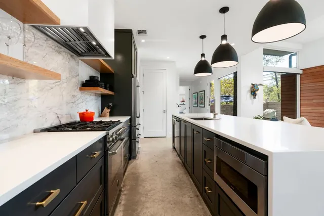 a kitchen with stainless steel appliances a stove and a wooden floors