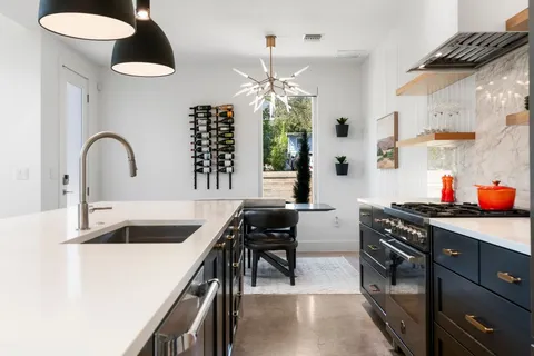 a kitchen with stainless steel appliances granite countertop a stove a sink and a microwave