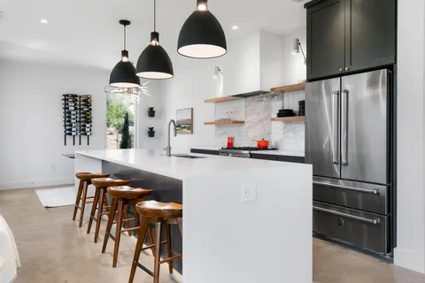a kitchen with stainless steel appliances granite countertop a refrigerator and a stove top oven
