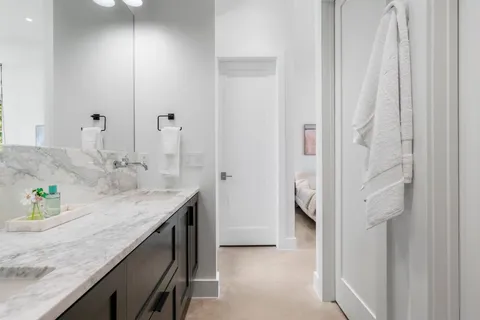 a en suite bathroom with a granite countertop sink and a mirror