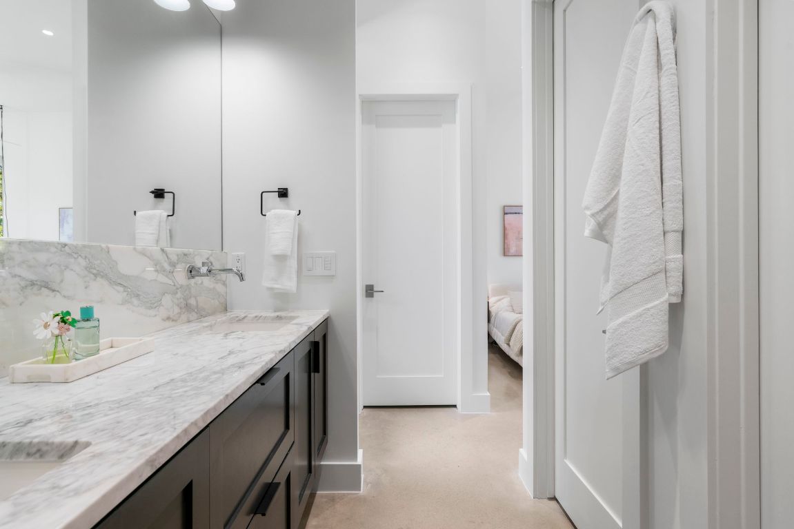 604 Cumberland Road Austin, TX 78704 - Photo 24 of 40 a en suite bathroom with a granite countertop sink and a mirror