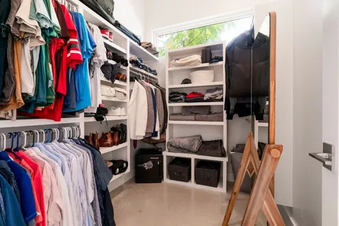 a view of walk in closet with clothes and shoes